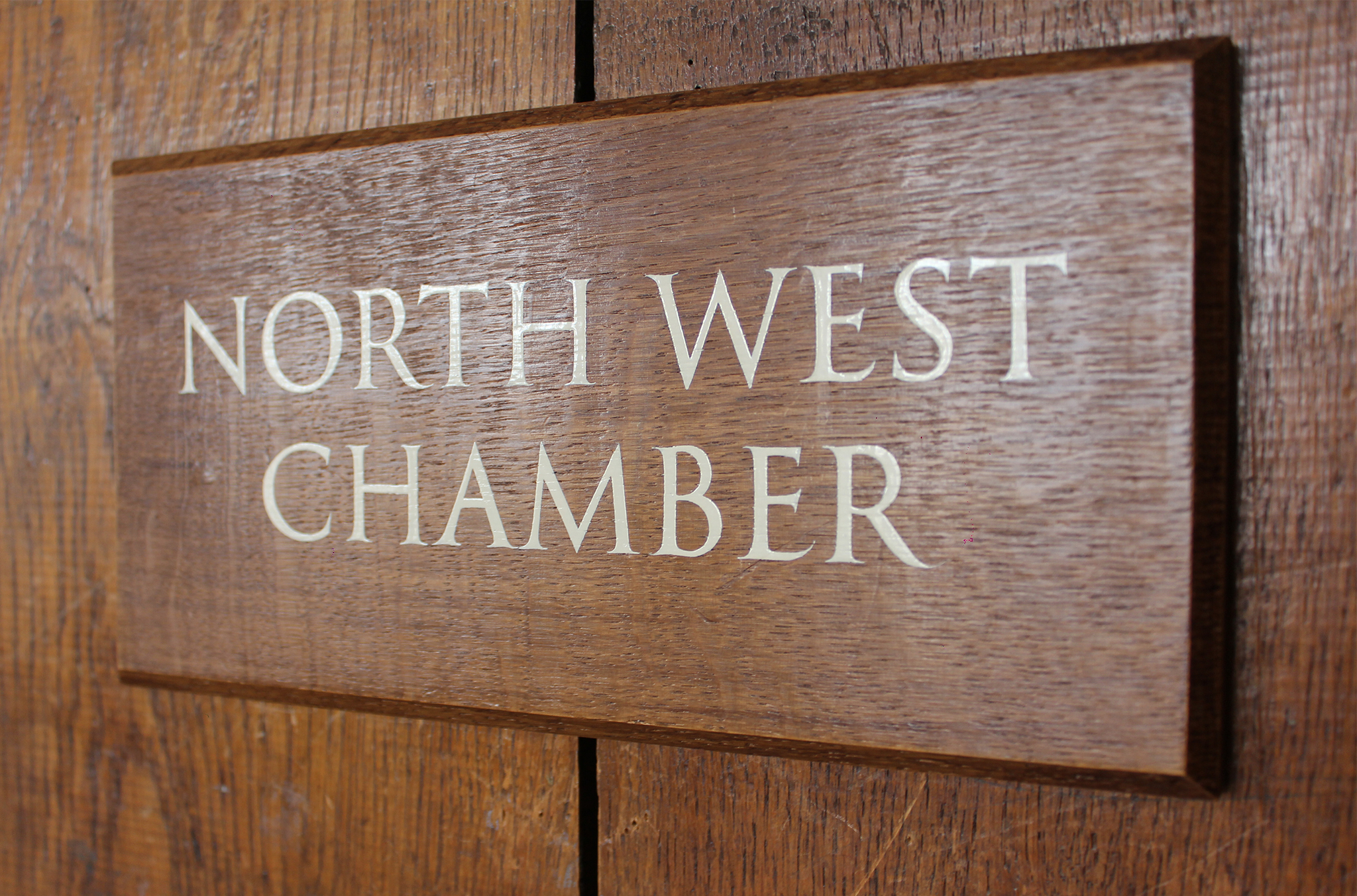 wooden door sign displaying the room name 'North West Chamber'